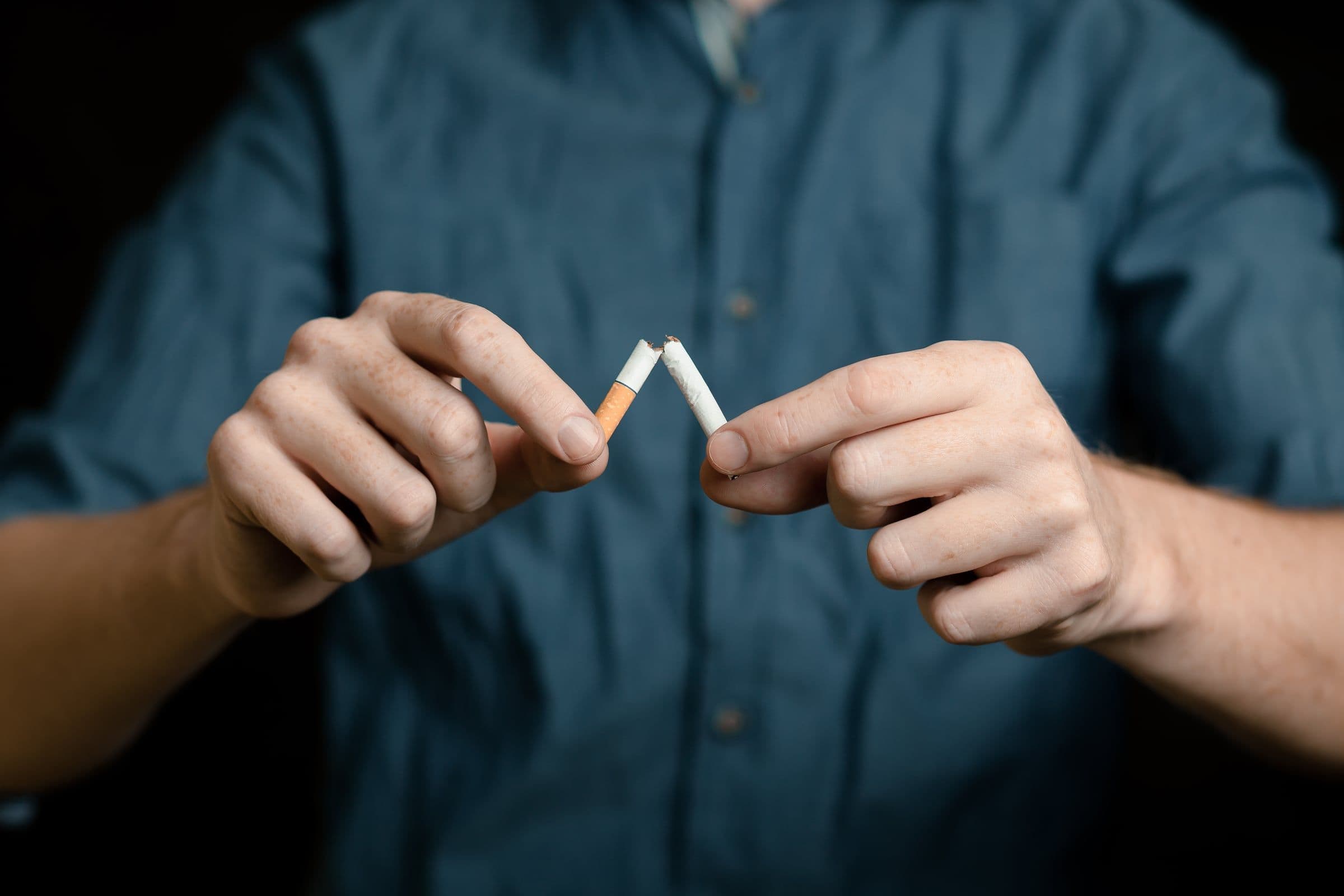 férfi kettétöri a cigarettát